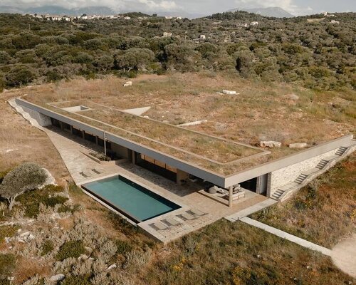 linear stone residence emerges within greek island’s untouched coastal terrain