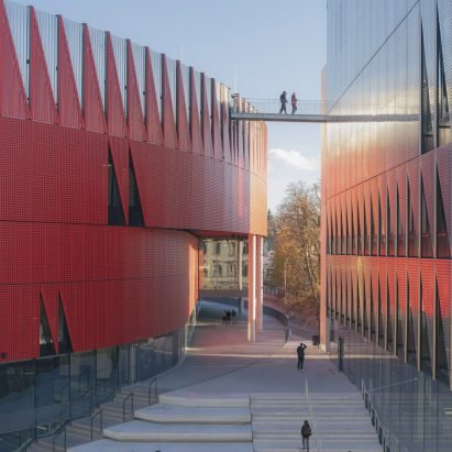 Red facade "evoking a hedgehog" wraps ice hockey arena by Chybik + Kristof